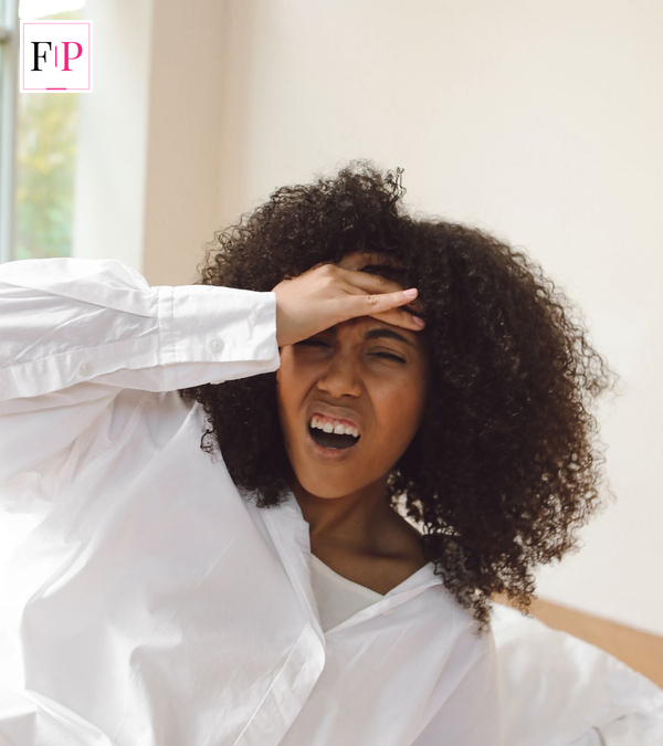 Young woman holding her head with a headache, one of the early brain tumour symptoms