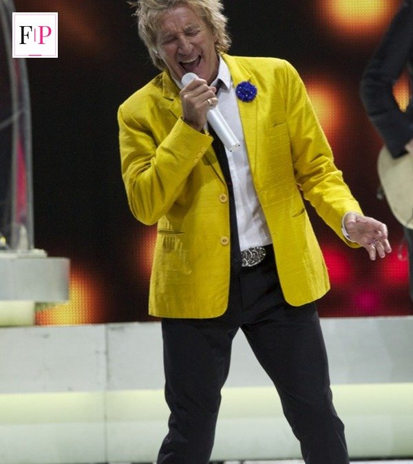 Rod Stewart in a yellow jacket singing on stage during a concert