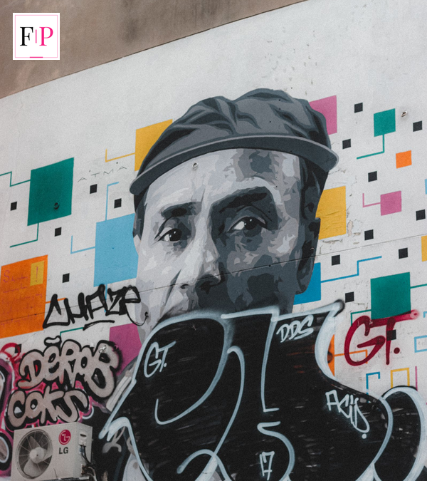 A graffiti portrait mural on a city wall, similar to the style linked with who is Banksy