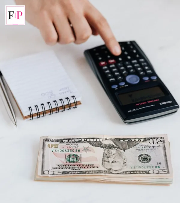 A hand using a calculator with a notebook at home — planning around the cash isa limit