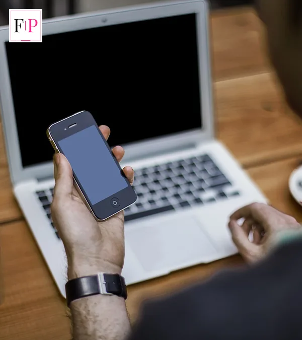 A person working at a desk with a smartphone and laptop — what to use while waiting for the chatgpt 6 release date