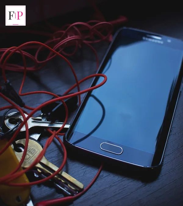 Android smartphone resting on a wooden desk with keys and earphones, for the google pixel 10a buying guide