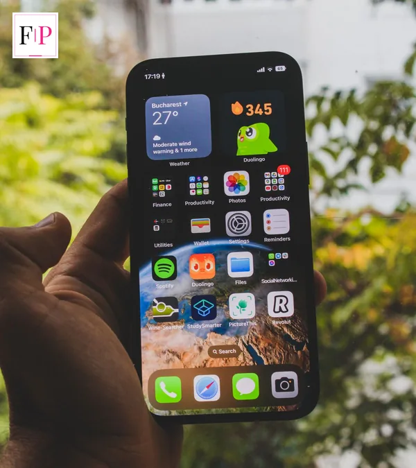 Hand holding a smartphone showing its home screen outdoors, for the iphone 17 pro max buying guide