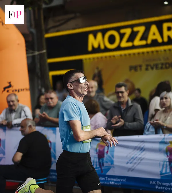 Runners racing through a city street cheered on by spectators — race day in a marathon training plan