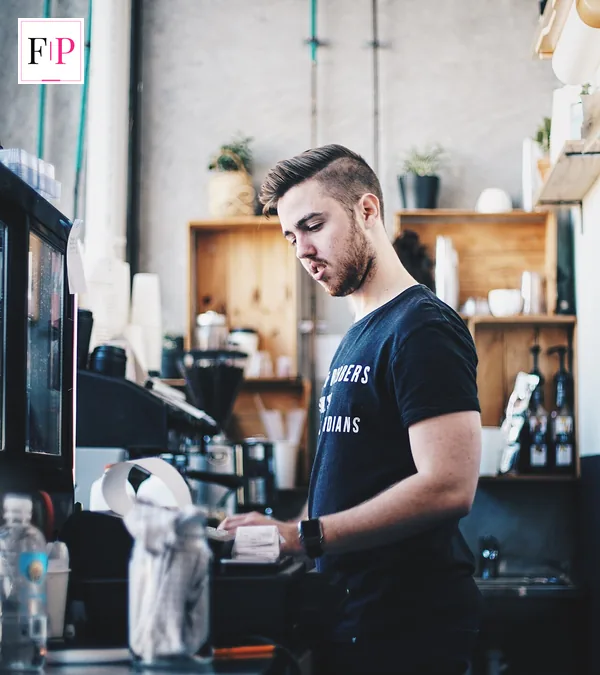 A café worker at the counter, one of the hospitality jobs paid at the minimum wage 2026